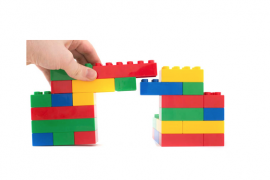 hand building a colorful bridge made out of toy blocks